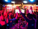 Público animado con las manos en alto en un evento nocturno
