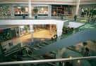 Interior del Centro Comercial Travesía con escaleras mecánicas y tiendas