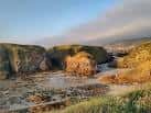 Calas rocosas y orilla de la playa de Santa Comba con marea baja
