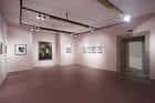 Sala de exposiciones interior con obras de arte y focos