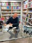 Autor firmando libros en el mostrador de una librería