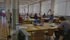 Interior de una sala de estudio o biblioteca con mesas y estudiantes
