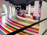 Interior moderno del Espacio Circus con suelo de rayas de colores y arcos