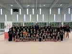 Grupo de gimnastas y entrenadores en el interior de un pabellón deportivo