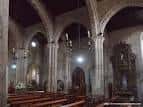 Interior de la iglesia con las naves laterales y arcos apuntados.