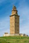 Vista frontal de la Torre de Hércules bajo un cielo azul claro