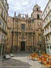 Fachada de la Iglesia de Santa Eufemia en una plaza urbana con mobiliario