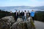Grupo de personas en un mirador rocoso con vistas panorámicas del paisaje