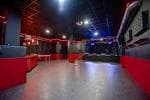 Vista general de la sala de eventos vacía con zona de baile y asientos rojos