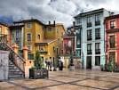 Plaza colorida en el Casco Antiguo de Oviedo con arquitectura tradicional y escalinatas
