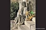 Estatua funeraria o escultura con ofrenda floral en el cementerio de Boisaca