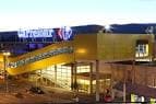 Vista exterior nocturna del Centro Comercial Carrefour Pontevedra con pasarela elevada