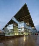 Perspectiva angular del Edificio Fontán destacando su cubierta inclinada y estructura moderna al anochecer