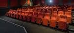 Interior del auditorio de cine (Duke's at Komedia) con filas de asientos naranjas