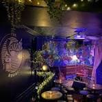 Vista interior del área de asientos y bar de The Folklore Rooms con iluminación ambiental