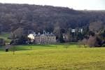 Vista panorámica de Stanmer House, el edificio histórico principal, rodeado de campos verdes y colinas boscosas