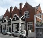 Vista exterior del New Venture Theatre, un edificio de ladrillo rojo y detalles en blanco y negro