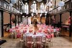 Interior de la sala principal de Fabrica, decorada para una recepción de boda con mesas redondas y globos