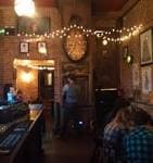 Vista interior del bar con paredes de ladrillo y luces decorativas de hadas