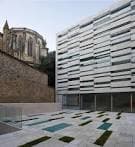 Vista exterior de la fachada moderna y el patio pavimentado del museo