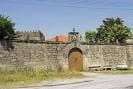 Muro exterior y entrada principal del Pazo Das Eiroás bajo cielo azul