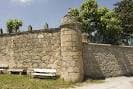 Vista lateral del muro de piedra del Pazo Das Eiroás con bancos de descanso