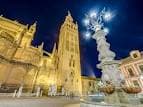 Perspectiva nocturna iluminada de la Giralda y la Catedral de Sevilla