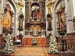 Detalle del altar mayor con ornamentación barroca y arreglos florales