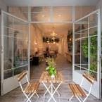 Acceso al local a través de puertas acristaladas blancas y zona exterior