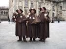 Grupo de tres peregrinos tradicionales en la Plaza del Obradoiro de Santiago