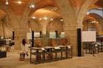 Sala de exposiciones del museo con arcos de piedra y vitrinas