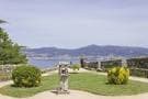 Área ajardinada con escultura y vistas al mar desde el Monte O Castro