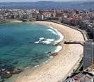 Panorámica aérea de las playas de Riazor y Orzán con olas rompiendo