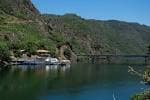 Vista panorámica del embarcadero de Ponte do Sil con catamaranes y el paisaje del cañón.