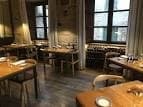 Salón de restaurante con mesas de madera y ambiente acogedor