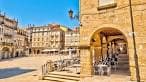 Plaza soleada con terrazas y edificios históricos en Ourense