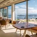 Interior del comedor con vistas panorámicas al mar en día soleado