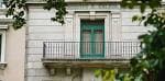 Detalle de balcón con puerta verde en la fachada del edificio