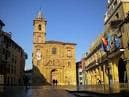 Perspectiva de la Plaza de la Constitución con la Iglesia de San Isidoro destacada por la luz del sol