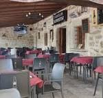 Zona de comedor exterior cubierta con mesas preparadas para eventos