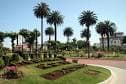 Vista panorámica de los jardines con palmeras y edificios