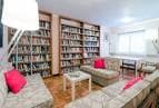 Sala de estar y biblioteca con estanterías llenas de libros y sofás