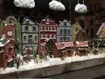 Exhibición de escaparate con un pueblo en miniatura nevado y elementos de manualidades
