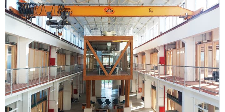 Interior moderno de la Cidade das TIC con estructura industrial y espacios abiertos