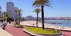 Paseo Marítimo de A Coruña con palmeras, playa y edificios de la ciudad