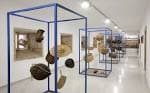 Galería interior del museo con exposición de objetos culturales en estructuras modernas.