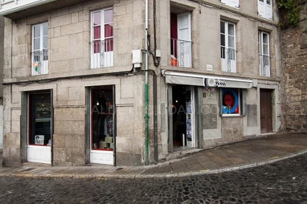 Vista exterior del edificio de piedra que alberga A Reixa Tenda en una esquina de la calle