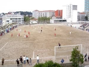 Campo de fútbol de tierra en el Colegio Hogar de Vigo con jugadores