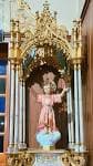Estatua del Divino Niño en un nicho dorado dentro de la iglesia