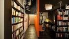 Interior de El Cercano con estanterías de libros y pasillo iluminado